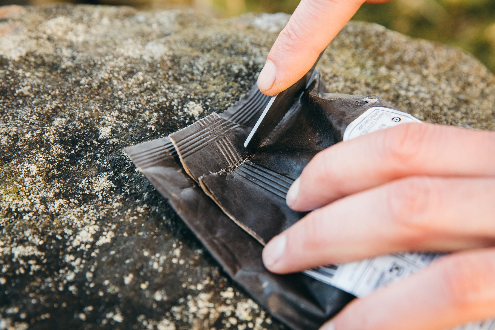 box cutter function of the muncher titanium multi camping utensil being used to cut packaging open